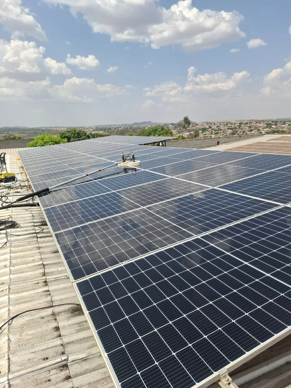 Equipamento de limpeza sobre painéis solares durante atendimento da R7 Manutenção
